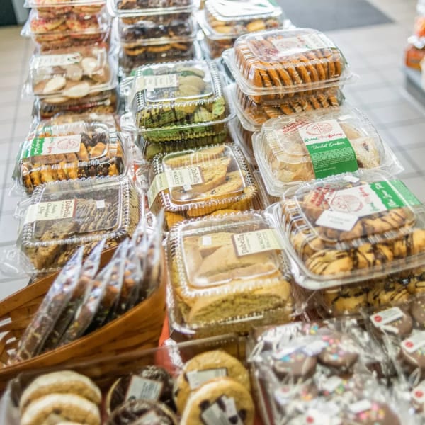 A display of various packaged cookies and biscotti, including Dabella and Bread & Butter Bakery brands.
