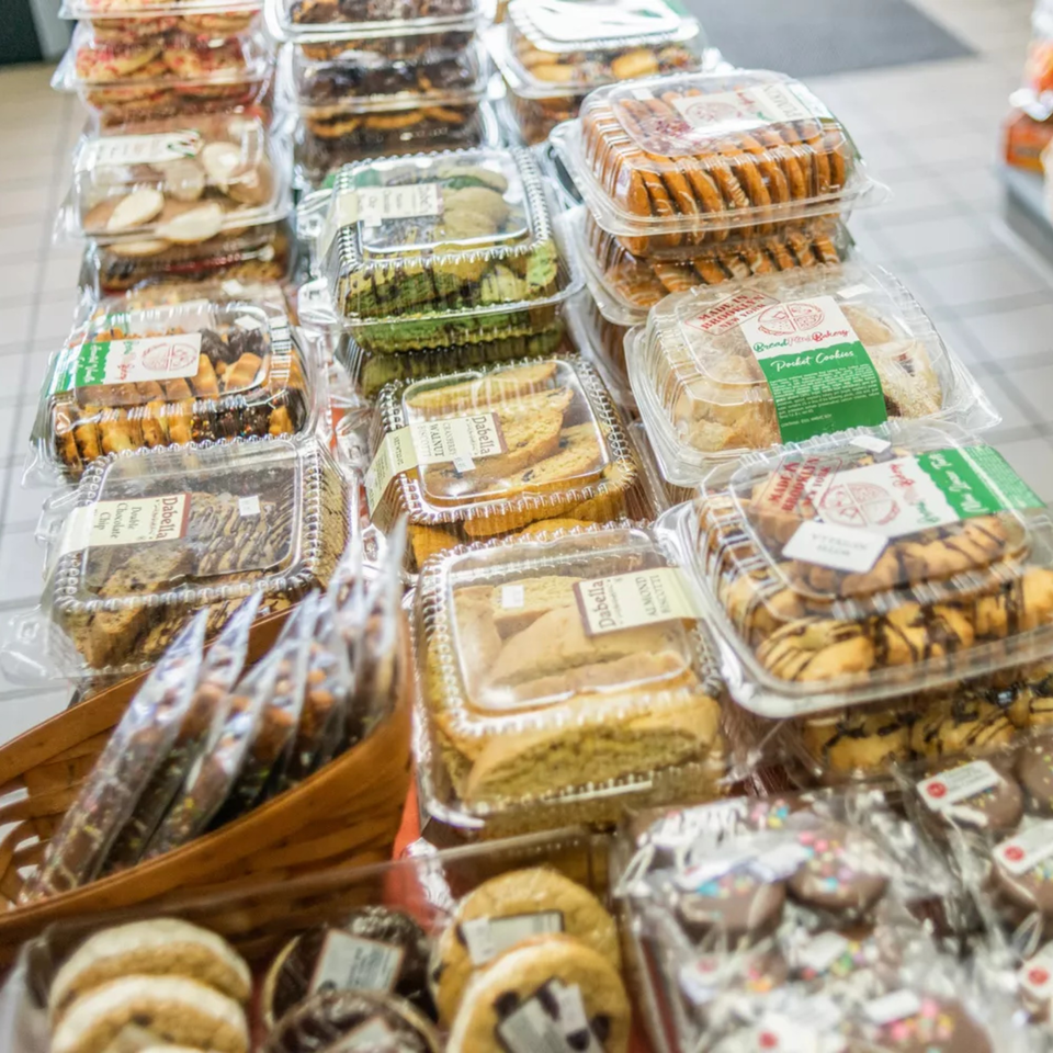 A display of various packaged cookies and biscotti, including Dabella and Bread & Butter Bakery brands.