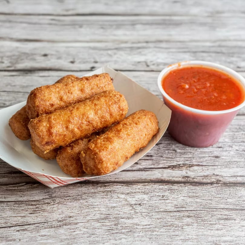 Golden-brown mozzarella sticks in a paper tray with a side of red marinara sauce.